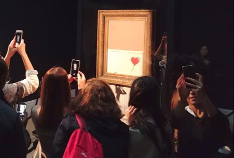Love is in the Bin de Banksy (intitulé avant l'auto-destruction Girl with Balloon) exposé après la vente chez Sotheby's à Londres, le 14 octobre 2018