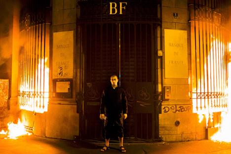 Action Éclairage : Piotr Pavlenski devant les fenêtres incendiées de la Banque de France à Paris, le 16 octobre 2017  - Photo Skin Cross