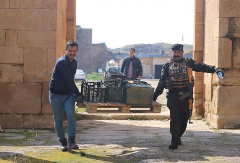 Transport de fragments de sculptures vandalisées à Hatra par les membres de la mission italo-iraquienne. © Ismeo.