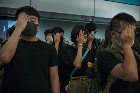La main sur l’œil droit, des manifestants témoignent leur solidarité envers une infirmière blessée à l’œil dix jours plus tôt par un tir de la police. Hong Kong, RAS, 21 août 2019. © Nicole Tung - Bourse de production pour les femmes photojournalistes du ministère de la Culture
