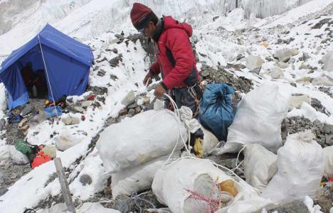 Un sherpa récolte des déchets sur le mont Everest. © Namgyal Sherpa/AFP