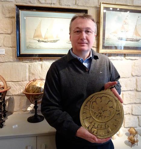 Éric Delalande tenant un astrolabe marocain du XVIIIe siècle. © Galerie Delalande Paris