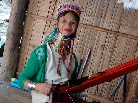 Femme Padaung utilisant un métier à tisser dans la Province de Chiang Mai en Thaïlande. À l'origine, les anneaux de cou en laiton étaient censés protéger la femme contre l'esclavage en la rendant moins attrayante pour les autres tribus. © Wayne77, 2014, CC BY-SA 4.0
