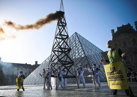 Action de Greenpeace devant la pyramide du Louvre en octobre 2021. © Anne-Christine Poujoulat / AFP