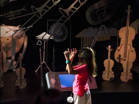 "Maestra, maestro" à la Philharmonie des enfants : l'enfant est placé dans la peau d'un chef d'orchestre dirigeant un orchestre symphonique. L'expérience est réalisée avec le concours d'IRCAM Amplify. © Nora Houguenade