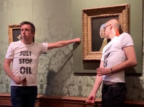 Militants écologistes vêtus du Tee-shirt du collectif « Just Stop Oil » devant le tableau de Vermeer « La Jeune fille à la perle », le 27 octobre 2022 au Musée Mauristhuis, Pays-Bas. © Twitter