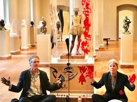 Les deux militants écologistes de Declare Emergency au pied de « La Petite Danseuse de 14 ans » d’Edgar Degas qu'ils viennent de vandaliser, à la National Gallery of Art de Washington, le 27 avril 2023. © Declare Emergency