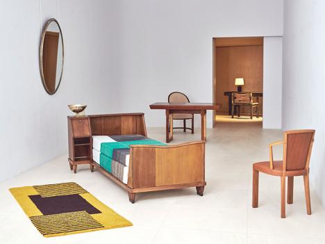 Reconstitution de la chambre du Vicomte Charles de Noailles : lit de Pierre Charreau (avant 1925), couverture de lit d'Hélène Henry, (vers 1930), tapis en laine d'Eileen Gray, chaise MF182 en noyer et en cuir (vers 1924), table/bureau MB 413 en acajou plaqué en sycomore (vers 1929), fauteuil Gondole (1922). © Galerie Maxime Flatry