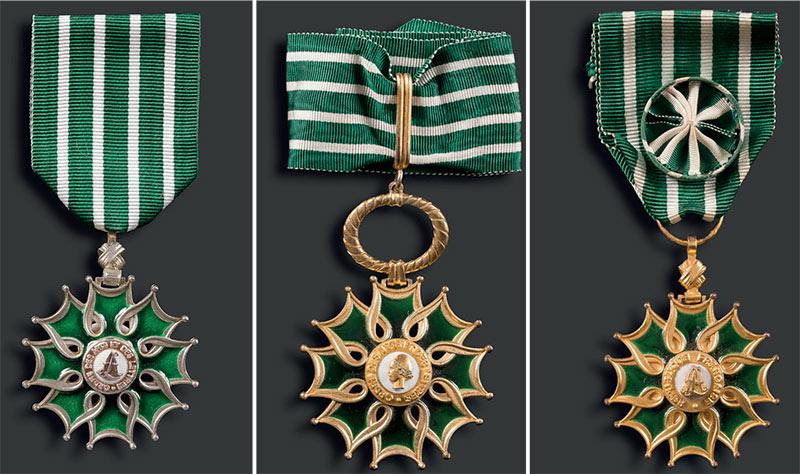 De gauche à droite : insigne de Chevalier, insigne de Commandeur, insigne d’Officier de l’ordre des Arts et des Lettres. © Ader.