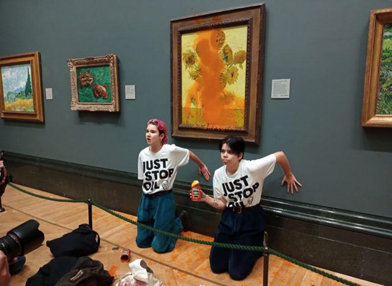 Militantes écologistes venant d'asperger la vitre protectrice des Tournesols de Van Gogh avec de la soupe, le 14 octobre 2022 à la National Gallery de Londres. © Just Stop Oil