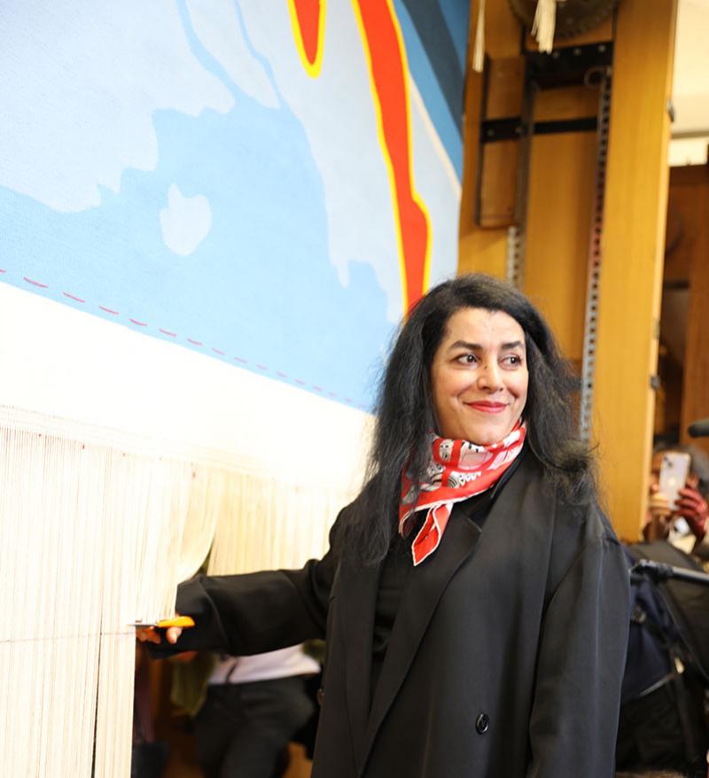Marjane Satrapi coupant les fils de chaîne de la tapisserie pour les Jeux olympiques de Paris 2024. © Aliénor de Carrière